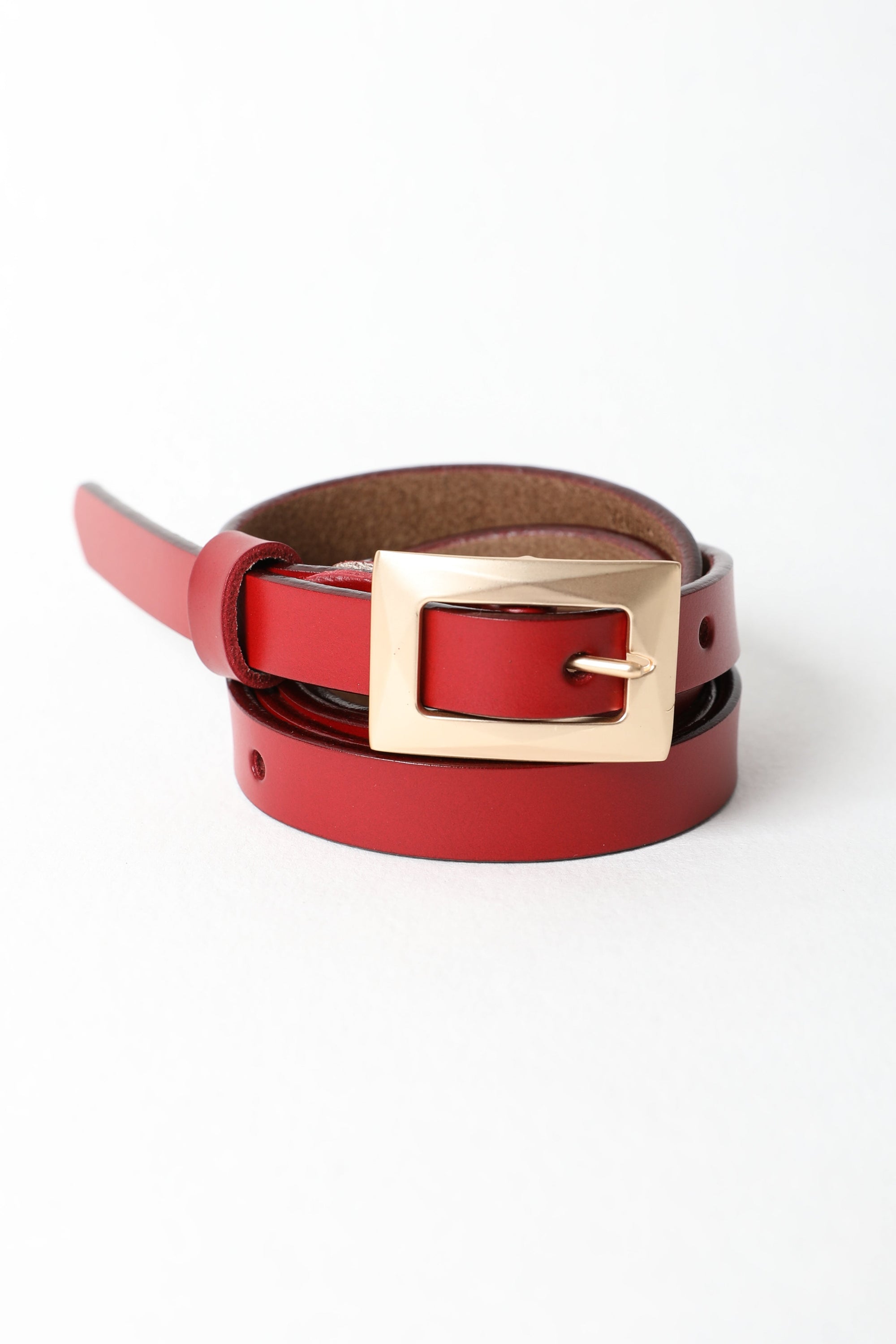 Gold buckle skinny waist belt with durable leather design.